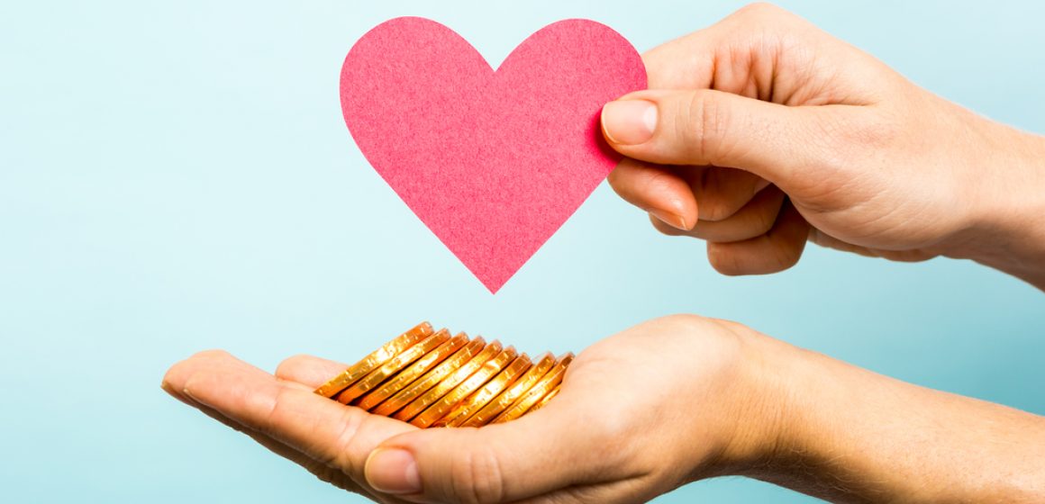 Golden coins, red heart paper shape. Love and money concept