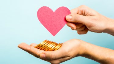 Golden coins, red heart paper shape. Love and money concept